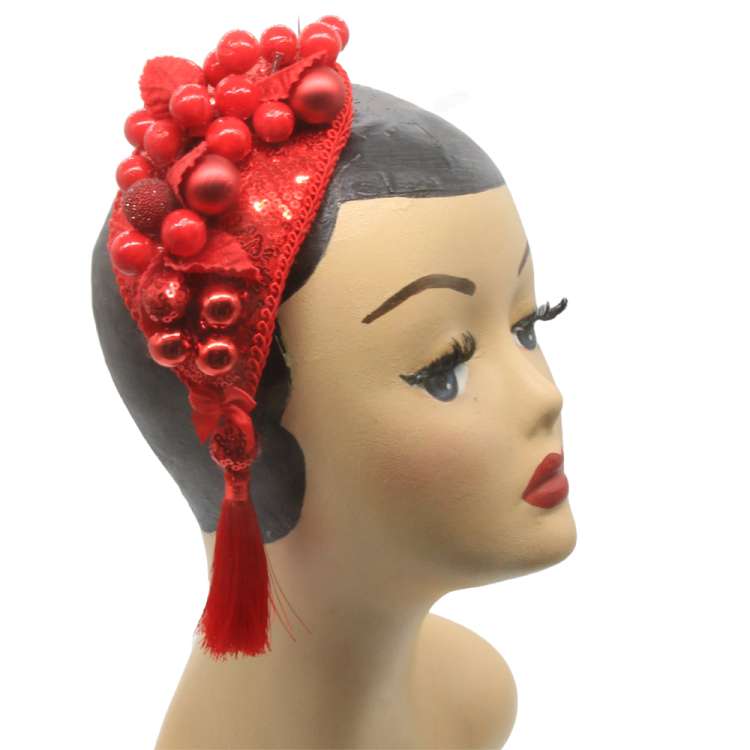 Kopf mit rotem Fascinator mit Beeren und kugeln in Rot